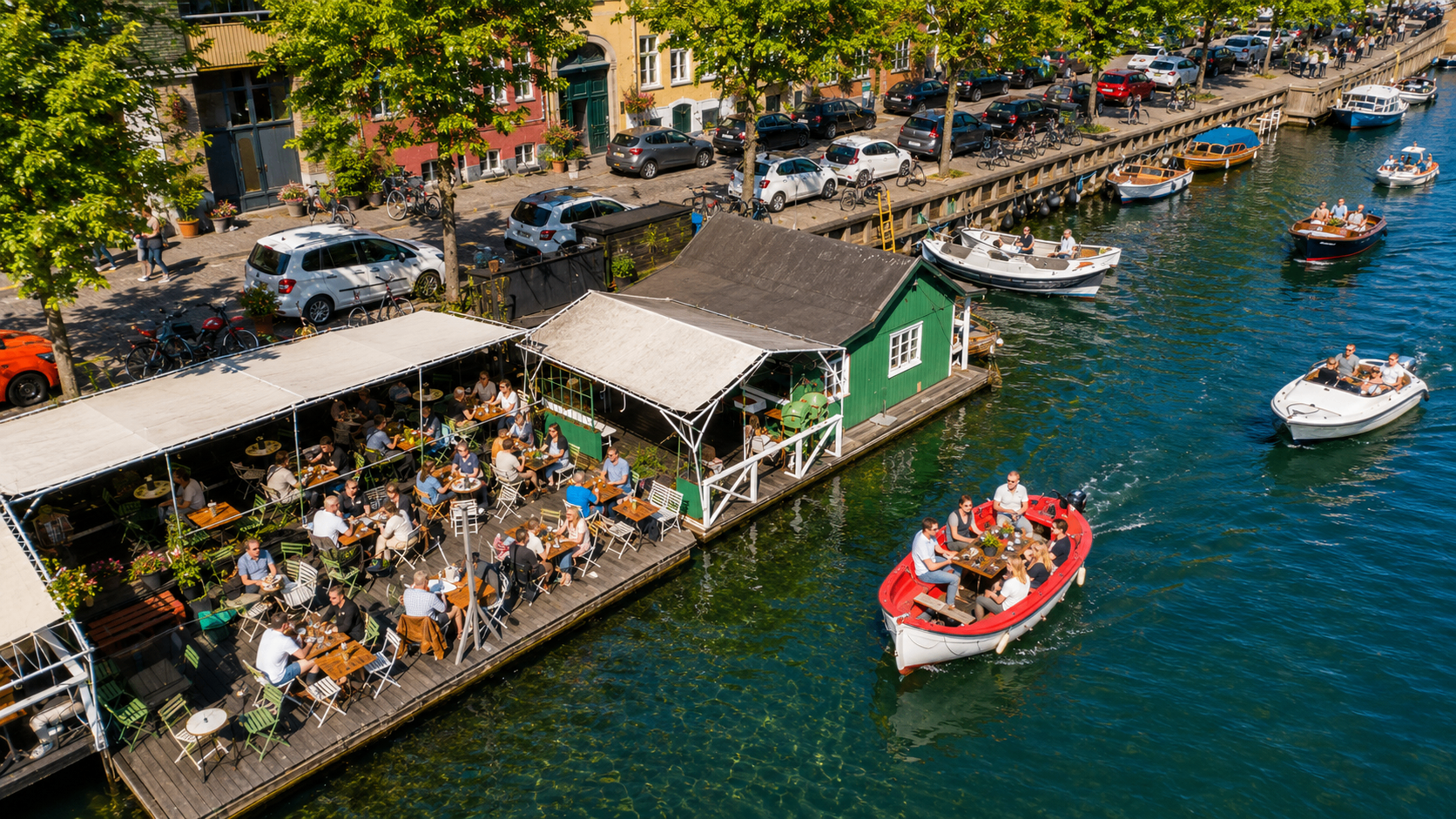 Red boat gliding past a floating canal café