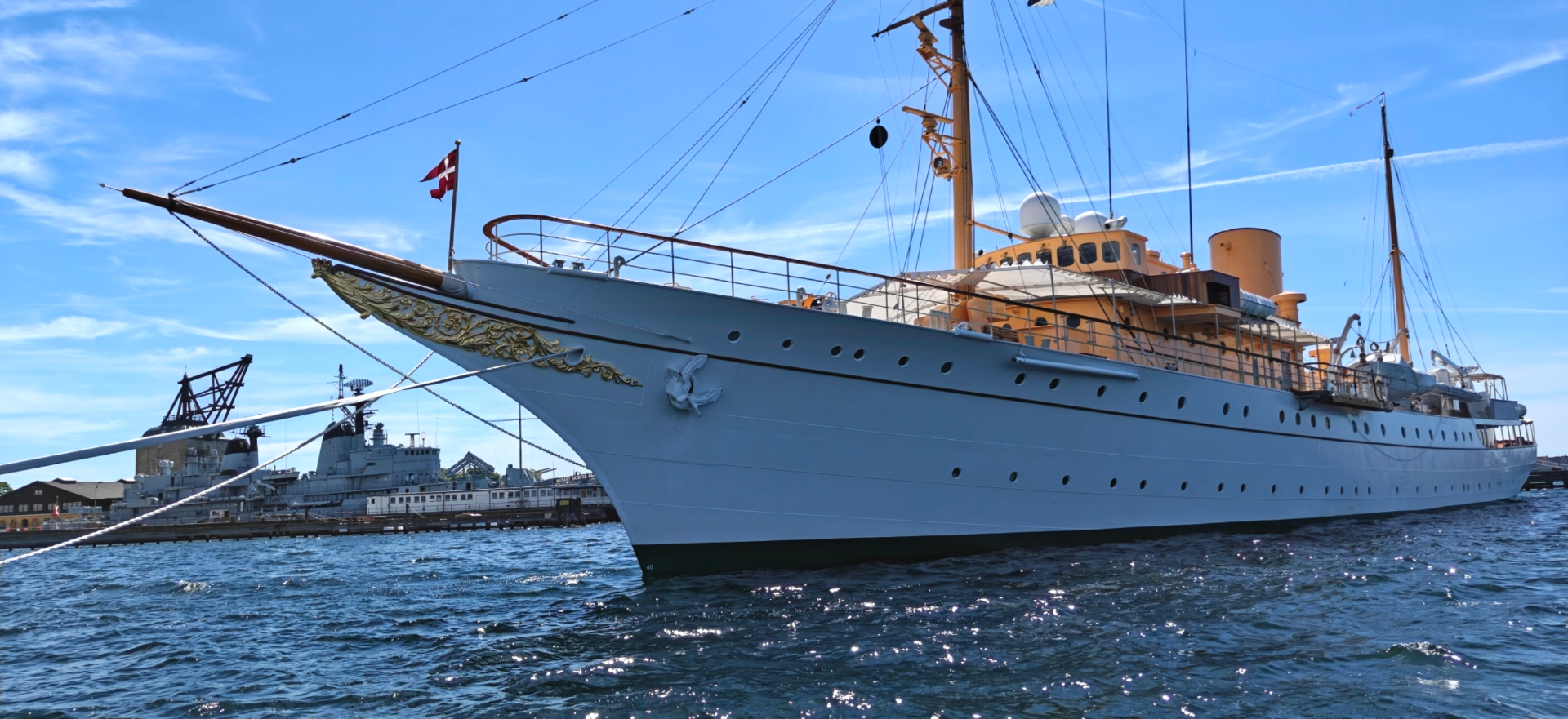 Elegant Danish royal yacht with golden bow details in Copenhagen harbor